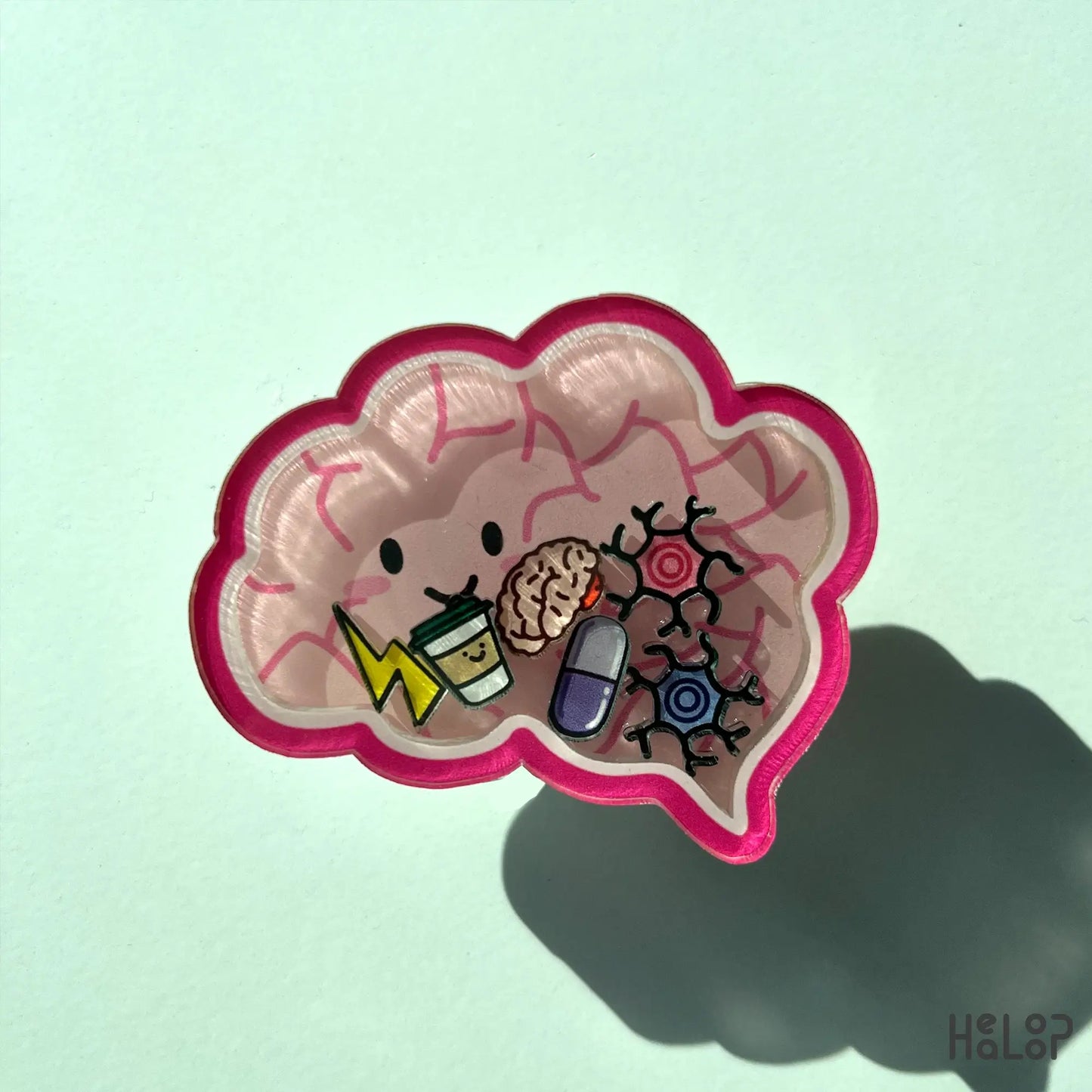 Anatomical brain-shaped shaker phone grip with charms on desk