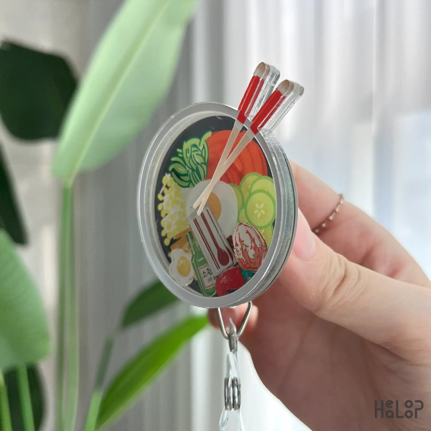 Angled side view of bibimbap shaker badge reel, durable retractable nurse ID clip