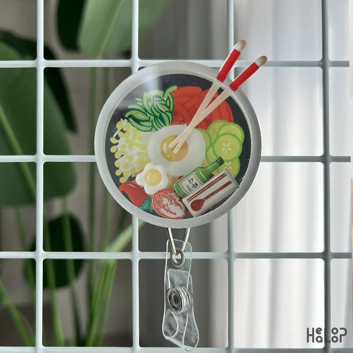 Korean bibimbap shaker badge reel displayed on wire grid, fun Asian food gift for nurses
