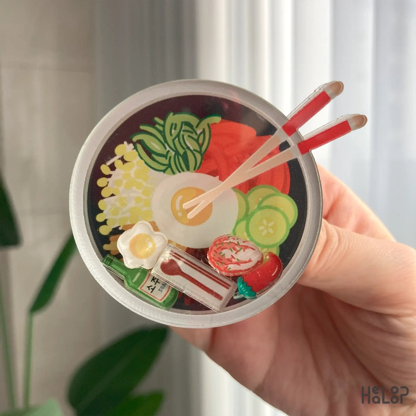 Detailed close-up of Korean bibimbap shaker phone grip with floating food charms