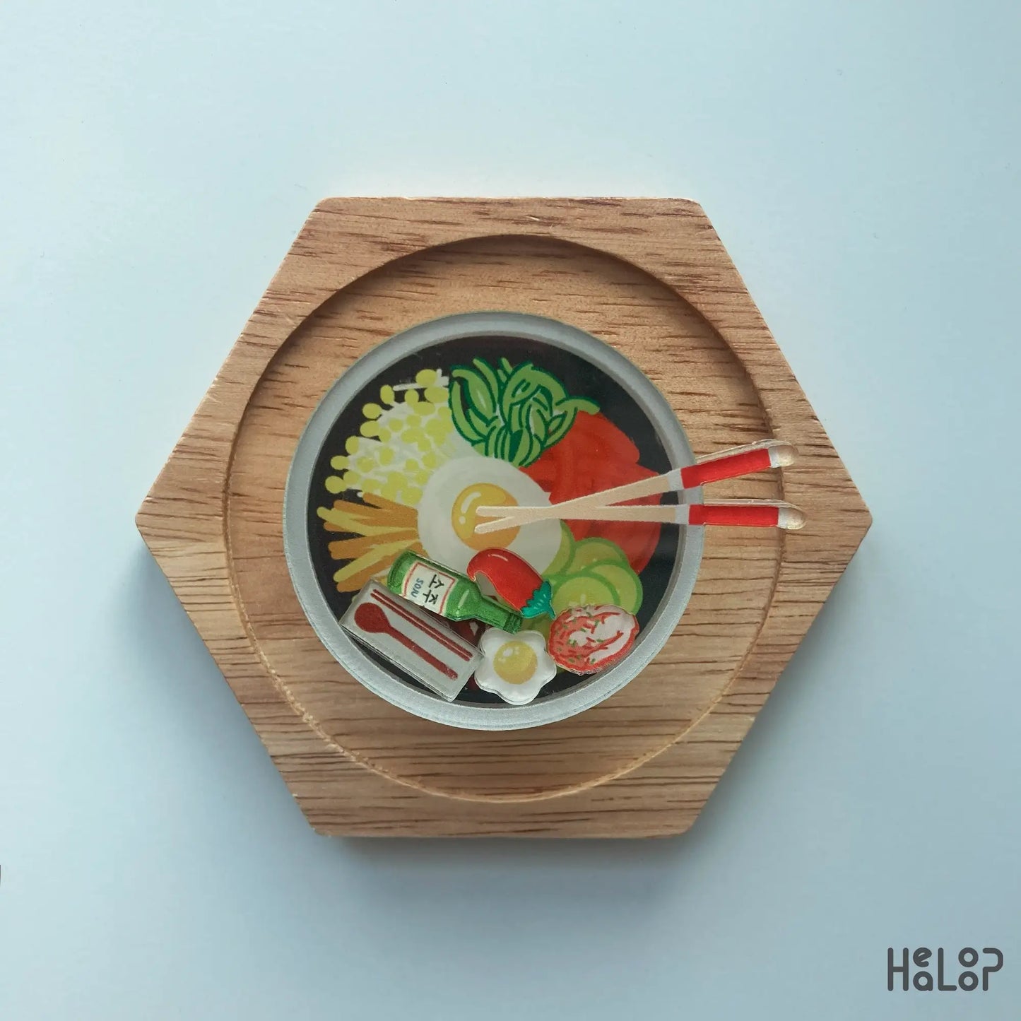 Korean bibimbap shaker phone grip flat lay on wooden stand, kawaii acrylic phone accessory