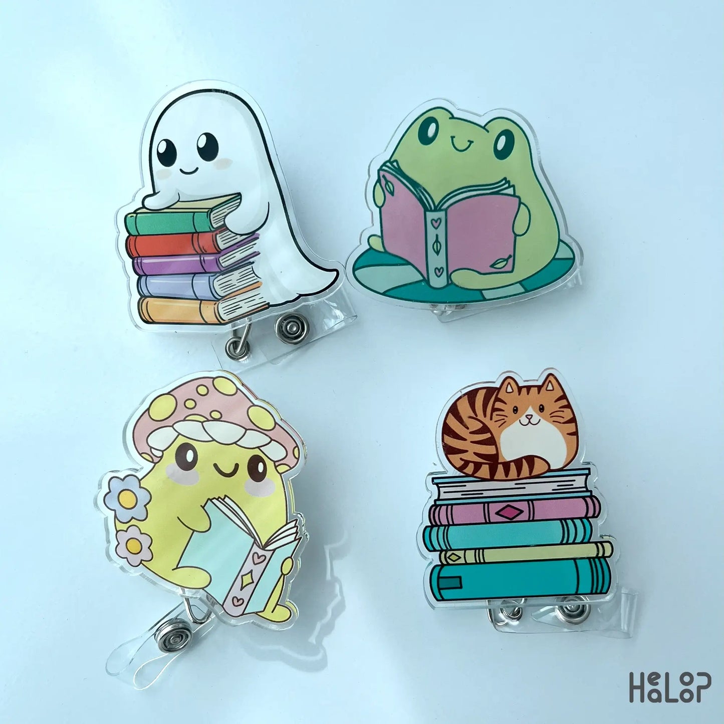Set of acrylic bookish badge reels featuring ghost, frog, mushroom, and cat characters