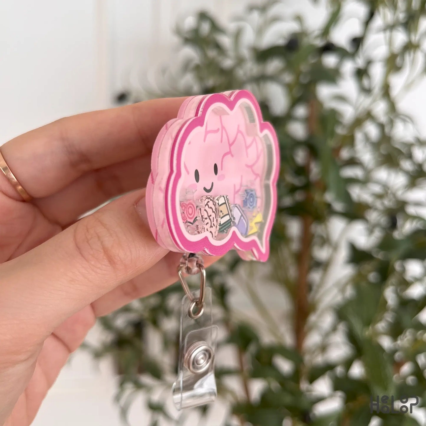 Side angle of shaker badge reel with mini brain and sparkle charms