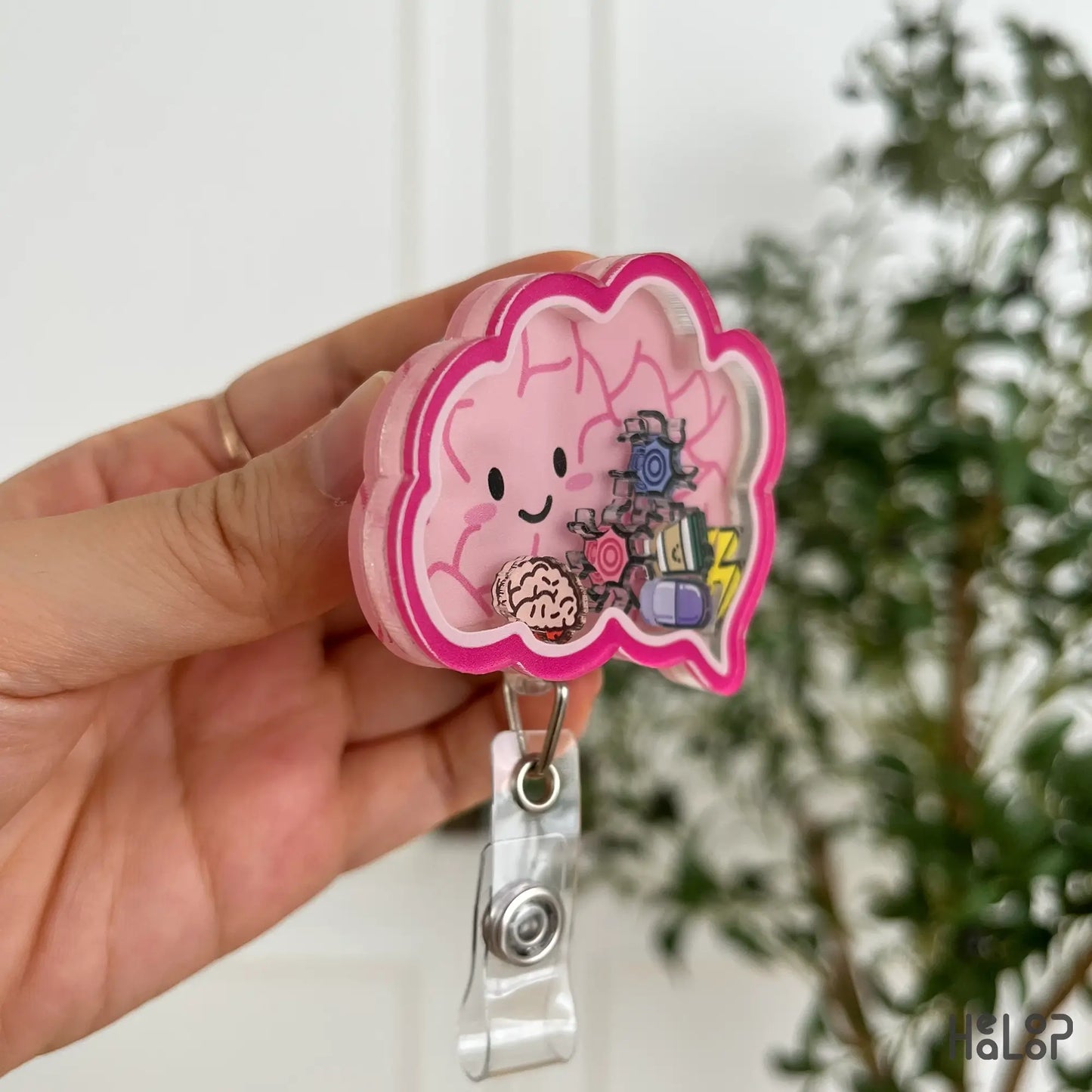 Side angle of shaker badge reel with mini brain and sparkle charms