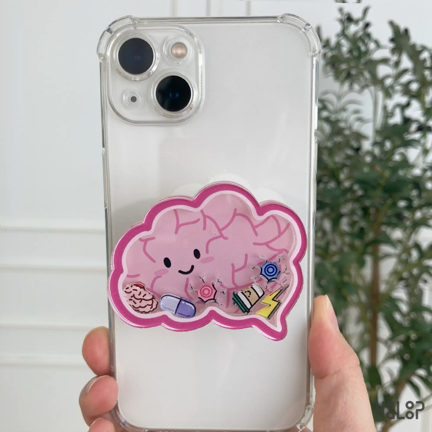 Pink brain shaker phone grip with charms attached to iPhone case