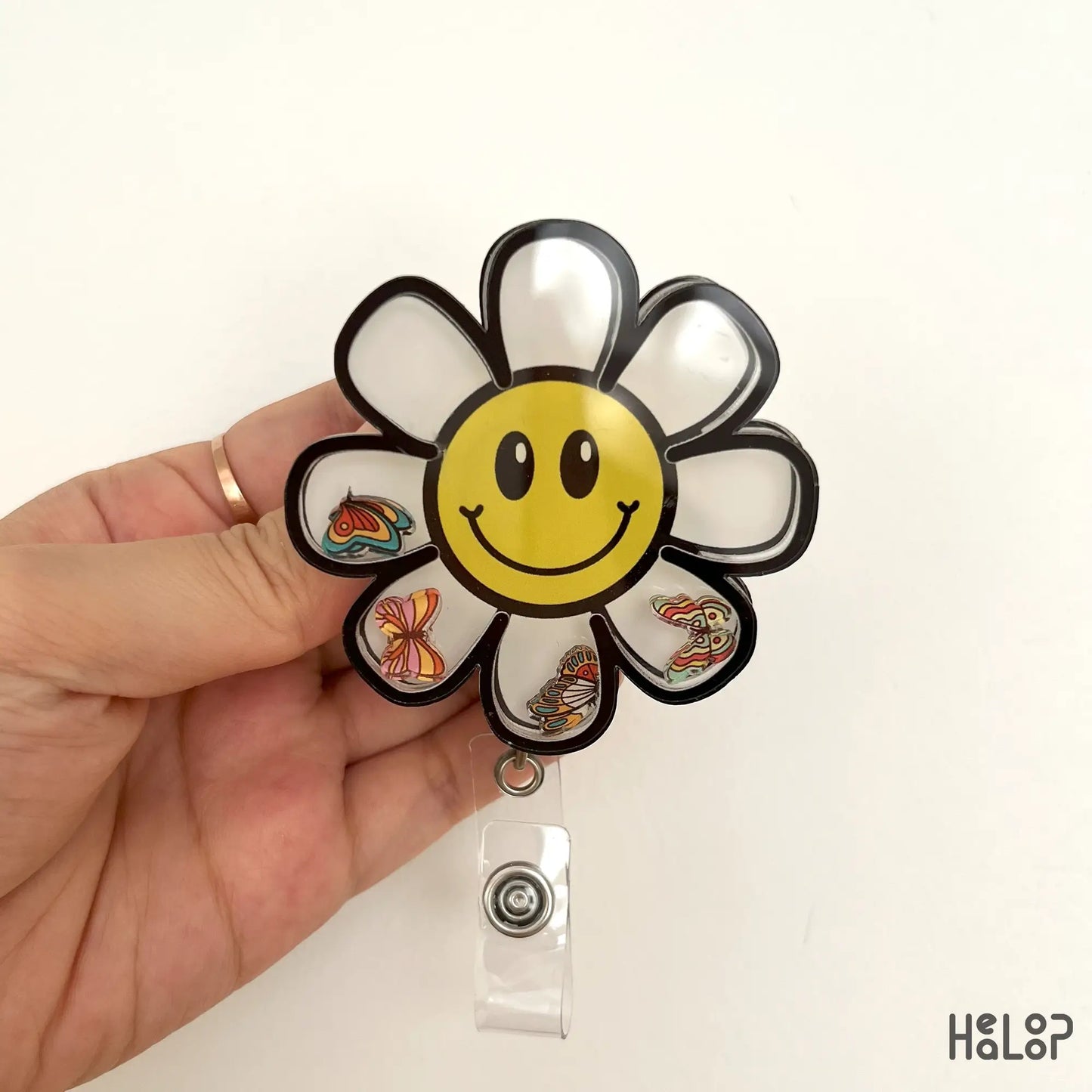 Daisy flower smiley face shaker badge reel with butterfly charms for nurse ID.
