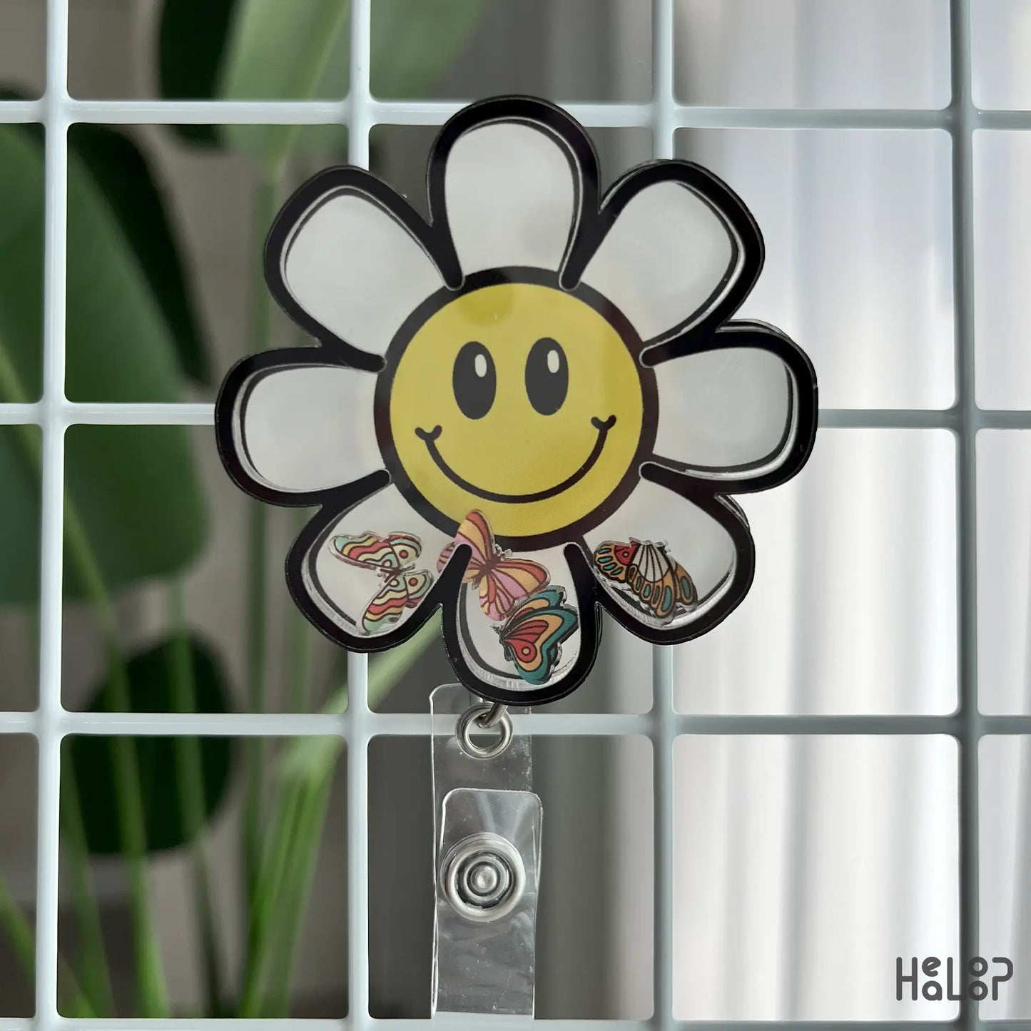 Fun daisy badge reel on grid background with butterflies inside shaker petals.