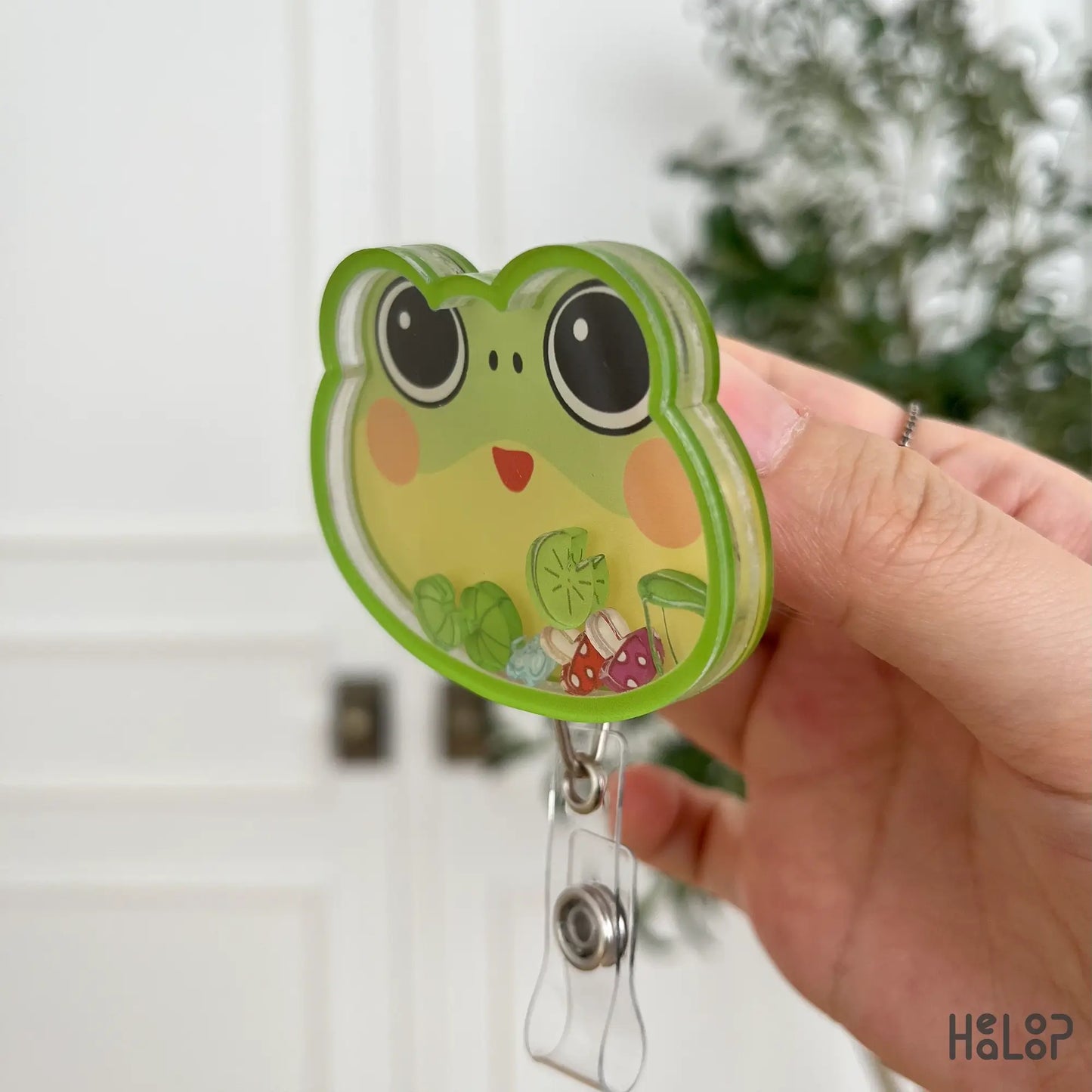 Side view frog shaker badge reel with shaker charms inside