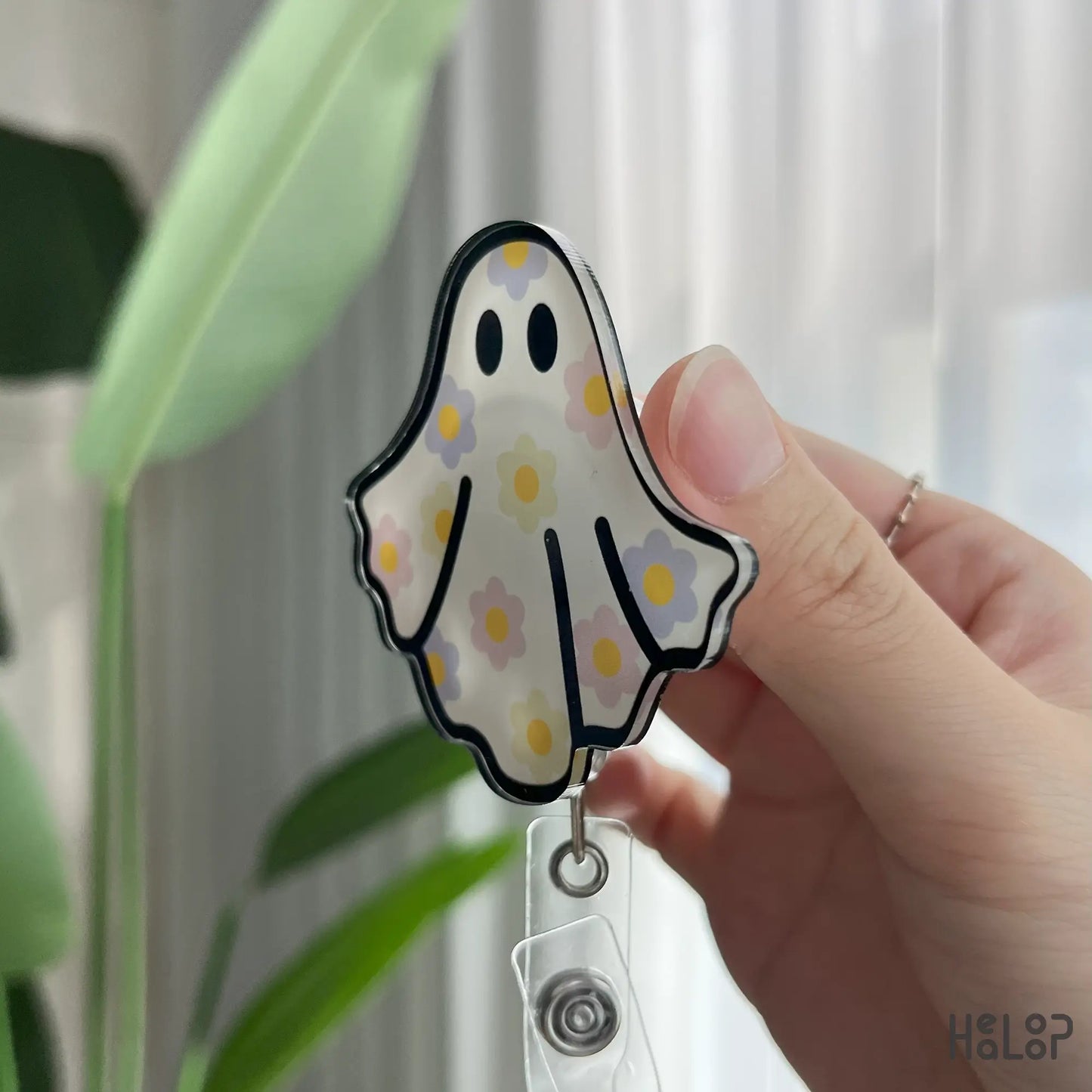 Angled view of floral ghost badge reel with pastel flower ghost design, durable ID holder