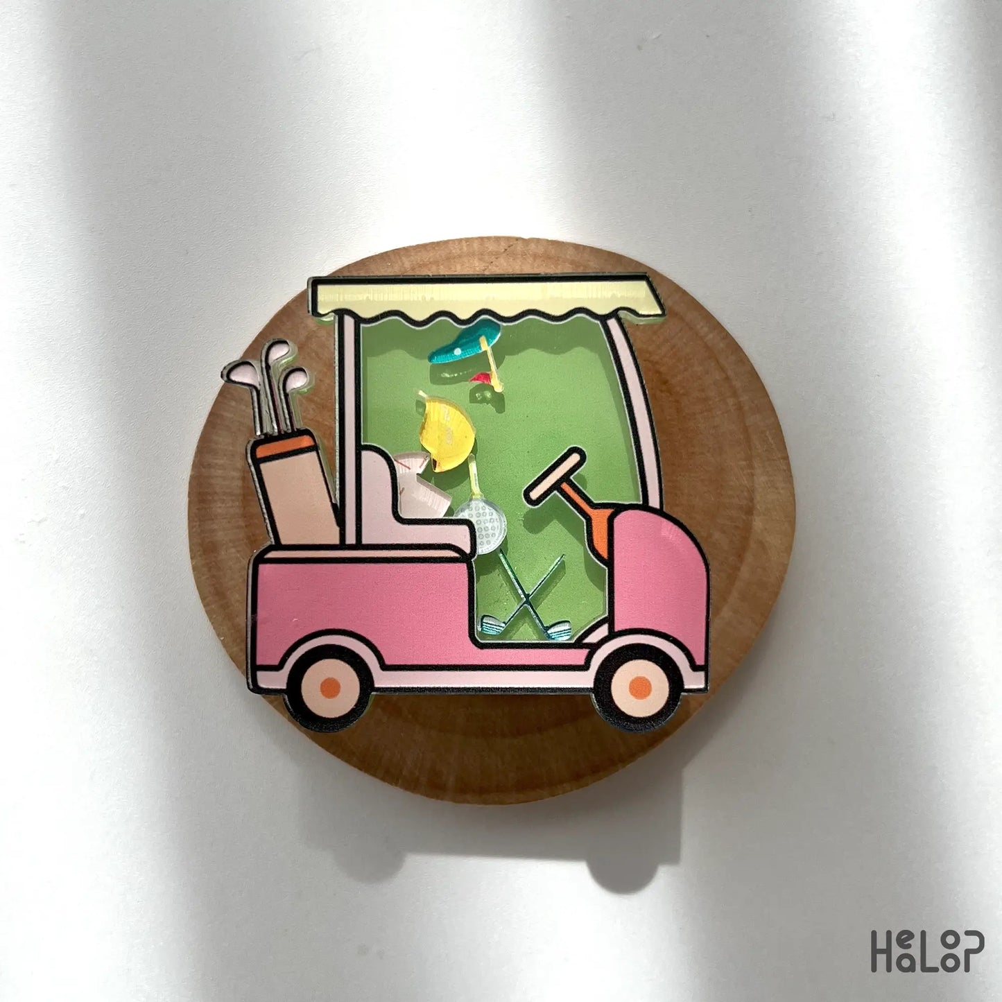 Fun golf cart shaker phone grip with floating golf accessories, displayed on wood background