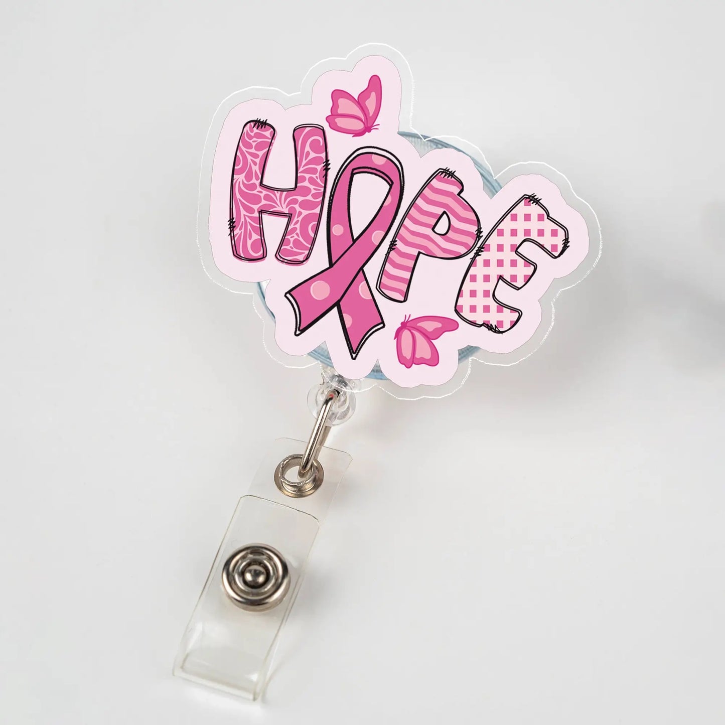 Retractable badge reel featuring the word “HOPE” with a pink ribbon and butterfly design, symbolizing breast cancer awareness.