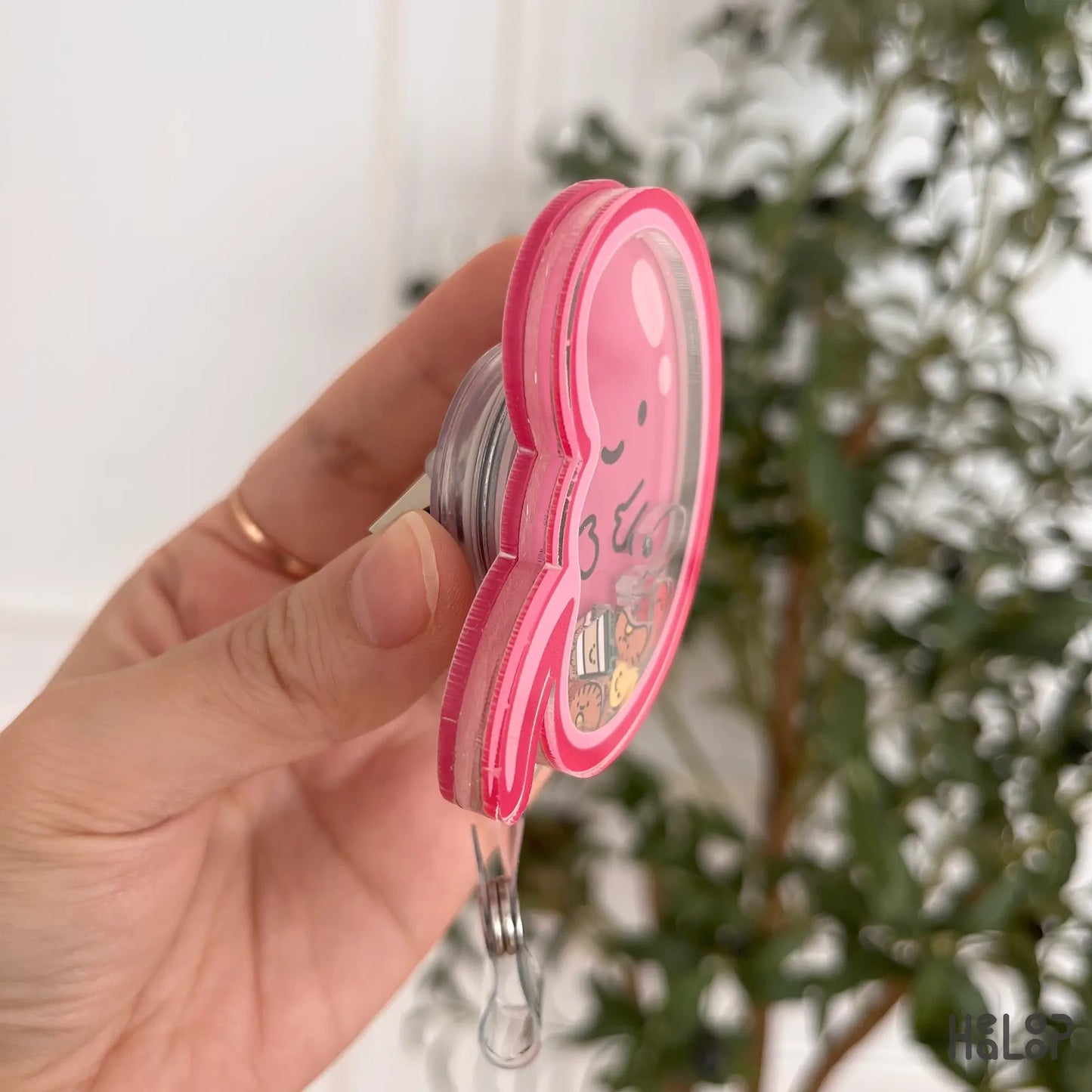 Close-up of floating pee and kidney charms inside kidney badge reel