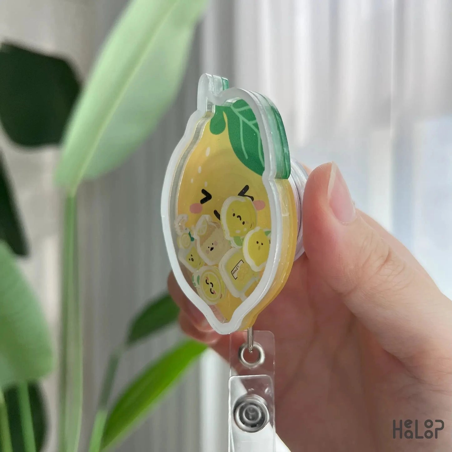 Side angle of Healoop lemon shaker badge reel showing acrylic layers and retractable clip