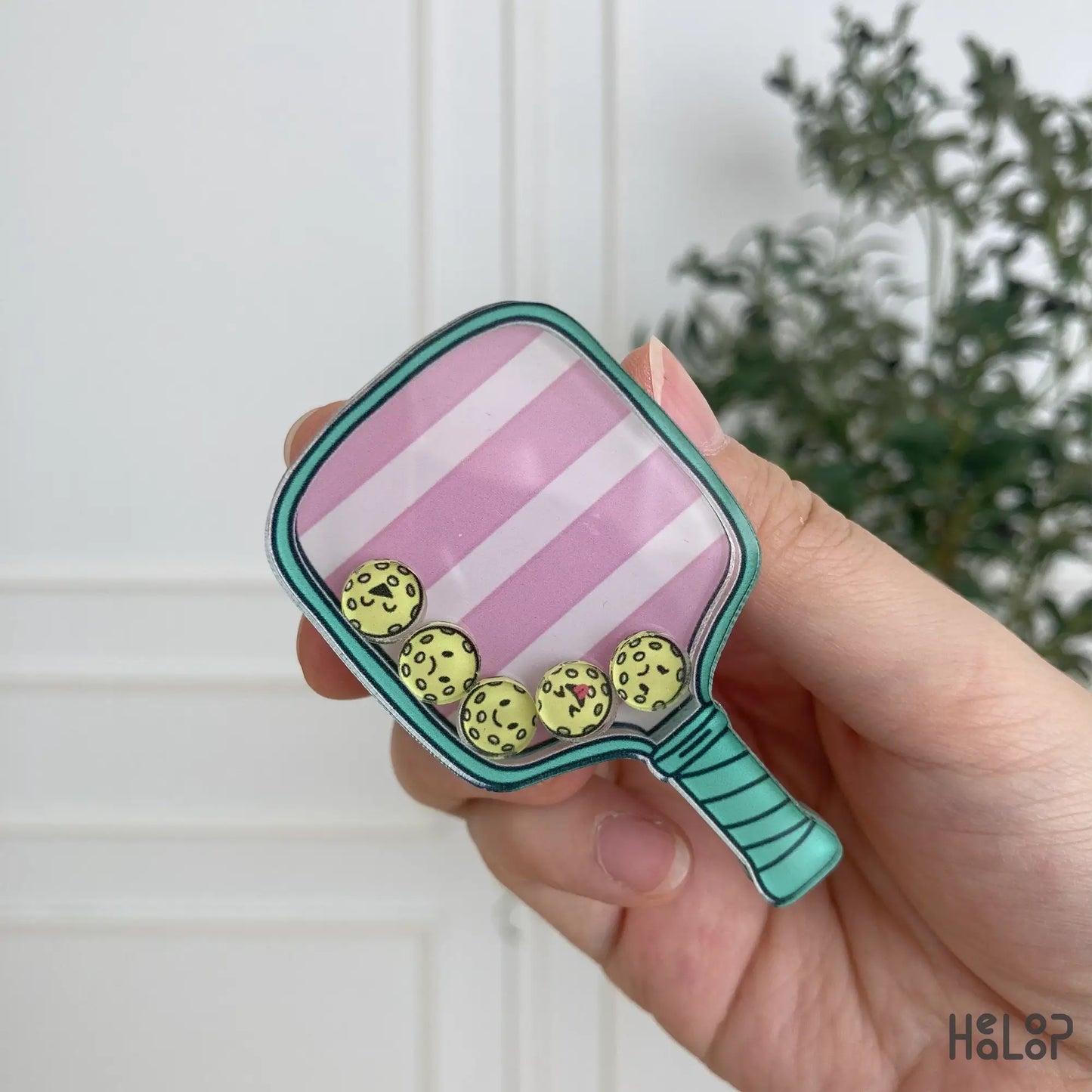 Close-up detail of pickleball shaker phone grip with charms inside
