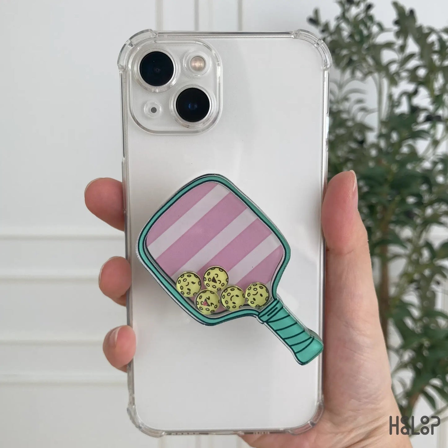 Person holding pickleball shaker phone grip attached to phone