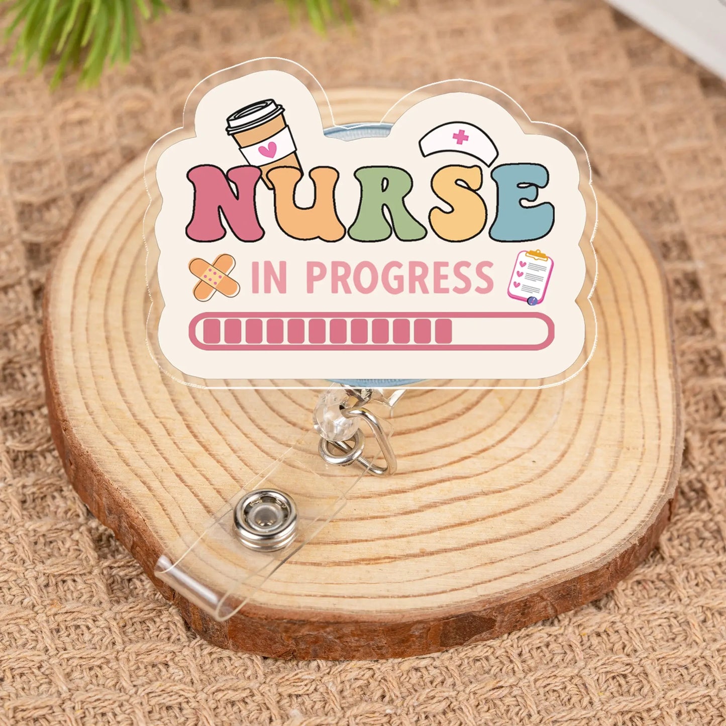 Colorful 'Nurse In Progress' badge holder on a wooden surface