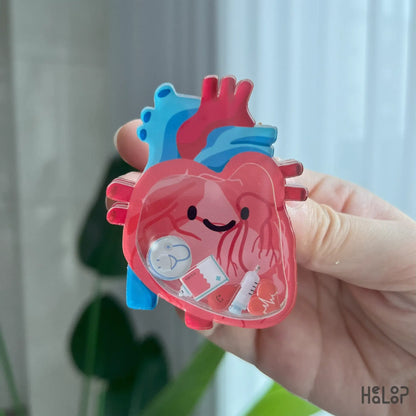 Detailed view of anatomical heart shaker phone grip with syringe and stethoscope charms