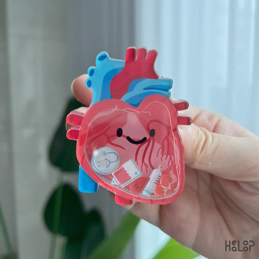 Detailed view of anatomical heart shaker phone grip with syringe and stethoscope charms