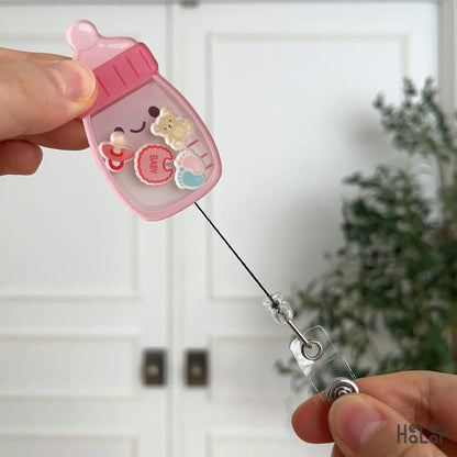 Baby bottle badge reel with retractable cord extended for easy ID access