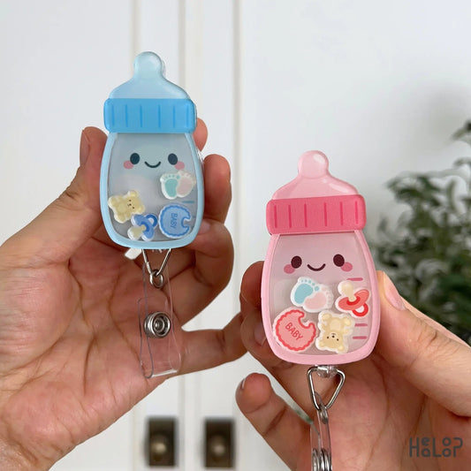 Cute pink and blue Baby Bottle Shaker Badge Reels with baby themed charms and retractable badge holders