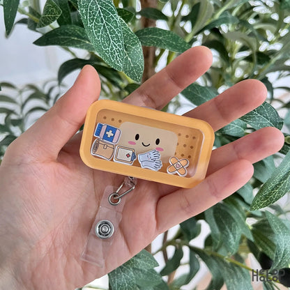 Bandage shaker badge reel with medical charms held in hand