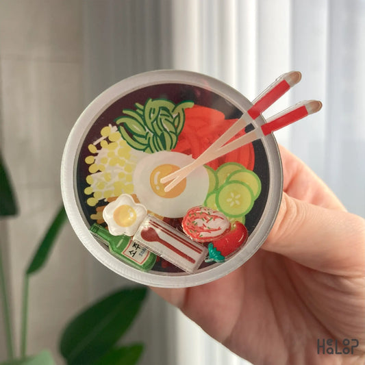 Detailed close-up of Korean bibimbap shaker phone grip with floating food charms