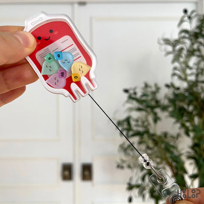Retractable medical badge reel shaped like a blood bag showing extended cord