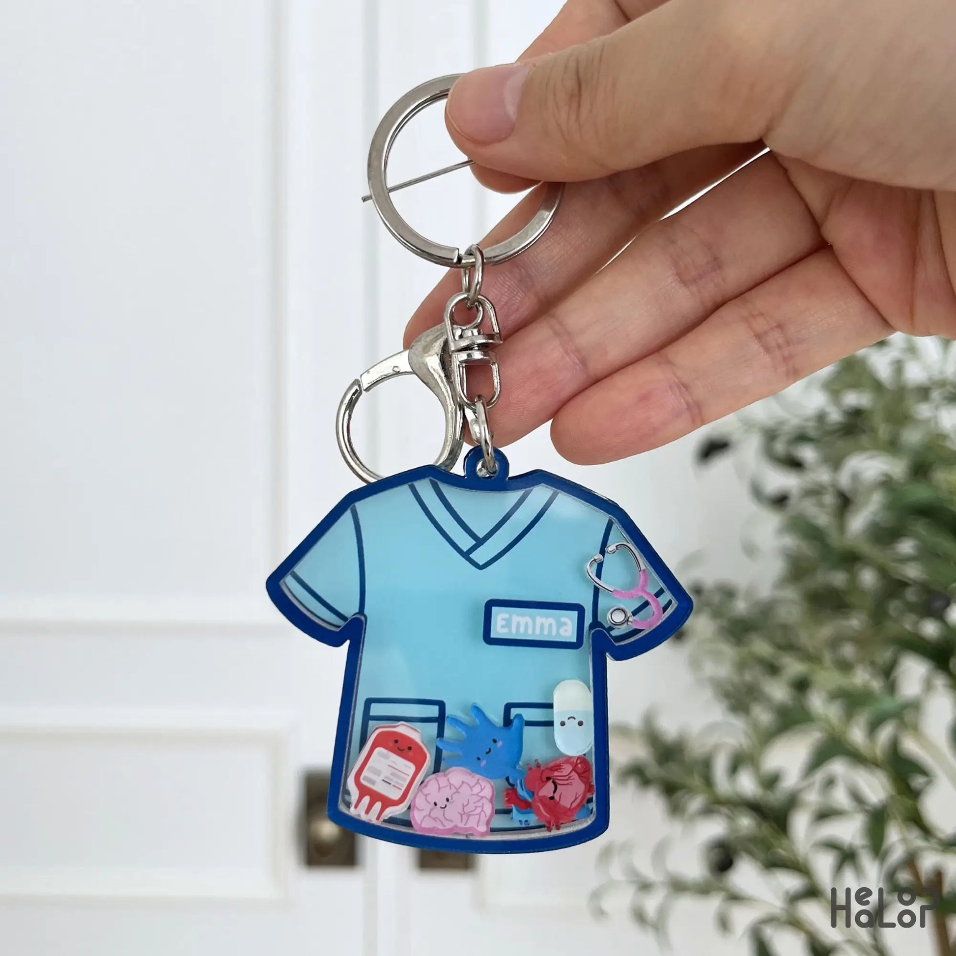 Blue personalized nurse shaker keychain featuring a custom name and colorful medical themed moving charms.