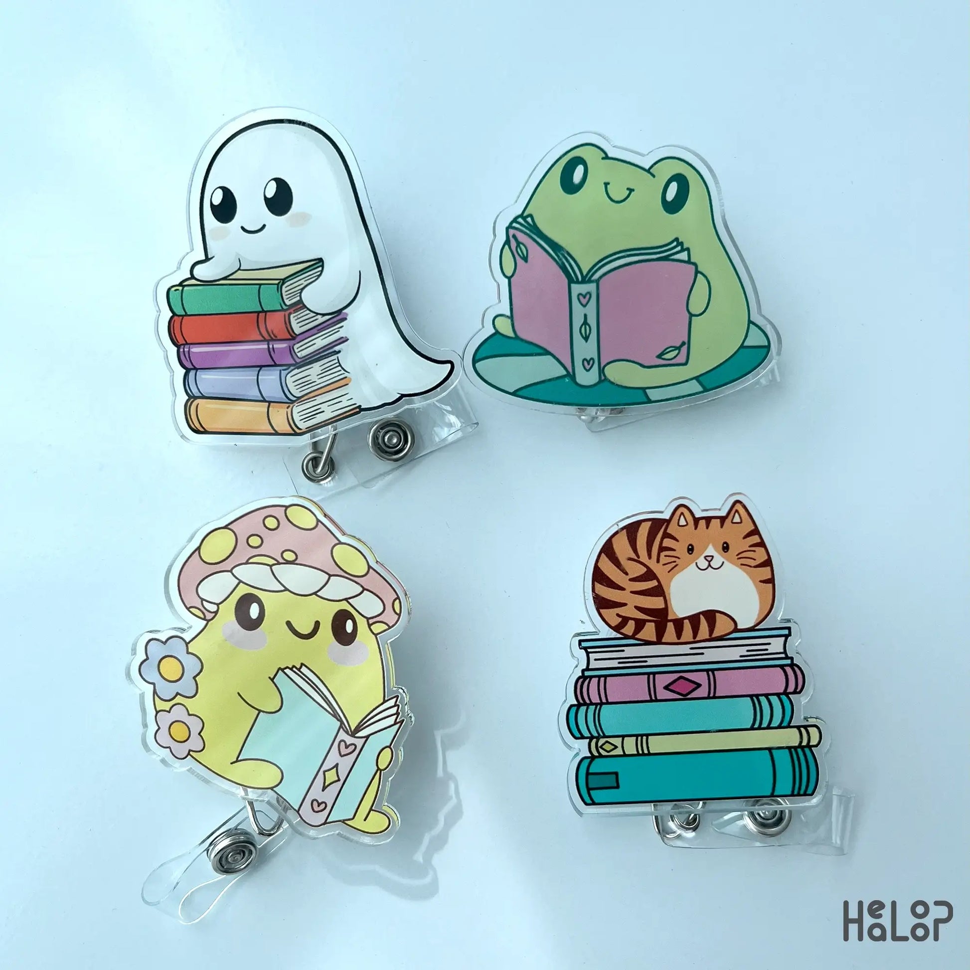 Set of acrylic bookish badge reels featuring ghost, frog, mushroom, and cat characters