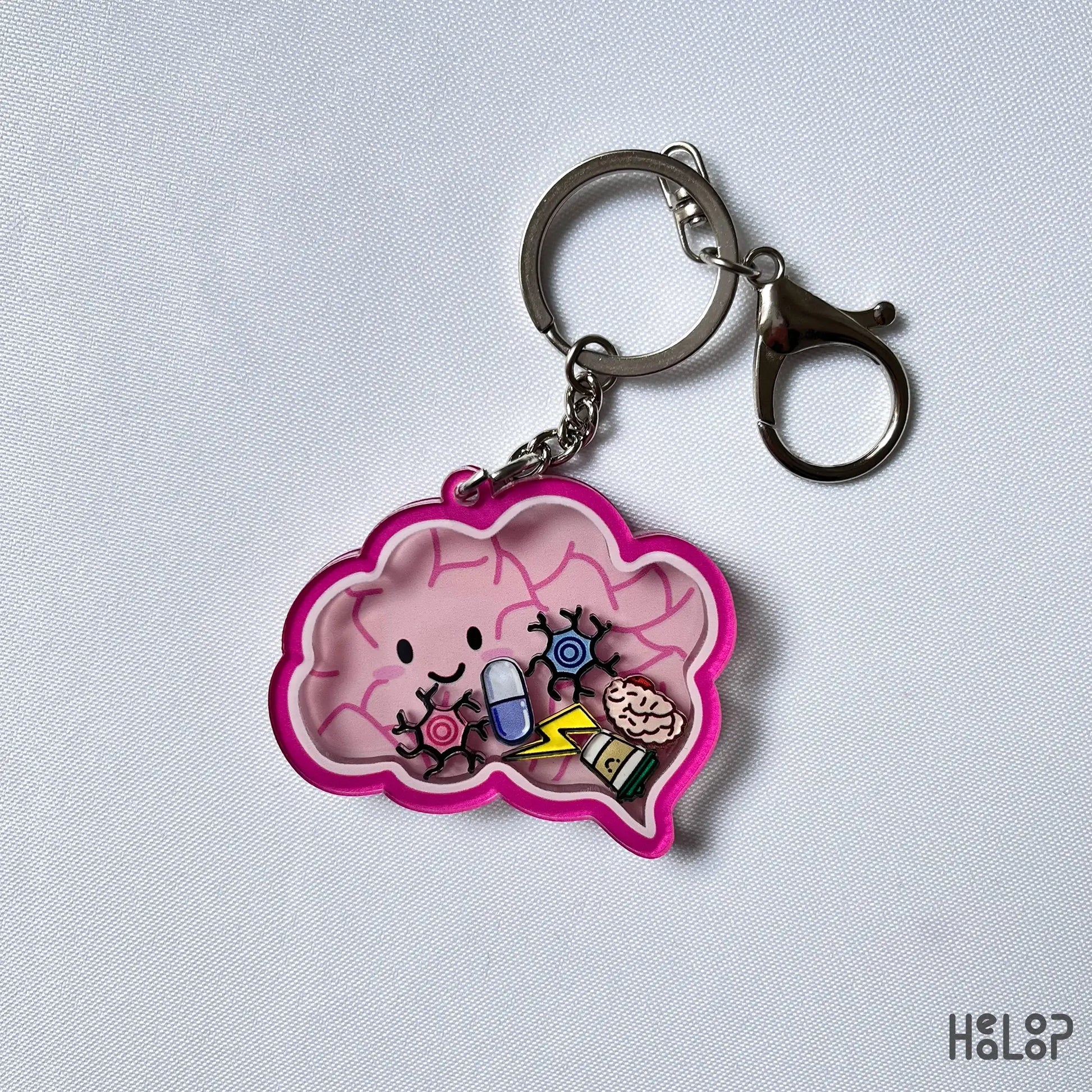 Brain shaker keychain displayed on white background with floating neuro-themed charms.