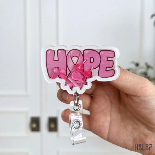Detailed view of Breast Cancer Hope Shaker Badge Reel with pink ribbon, butterfly, boxing glove, and pink awareness shaker charms.