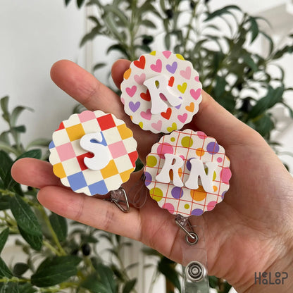 Colorful custom initial badge reels with personalized letters and RN design for nurses and healthcare workers