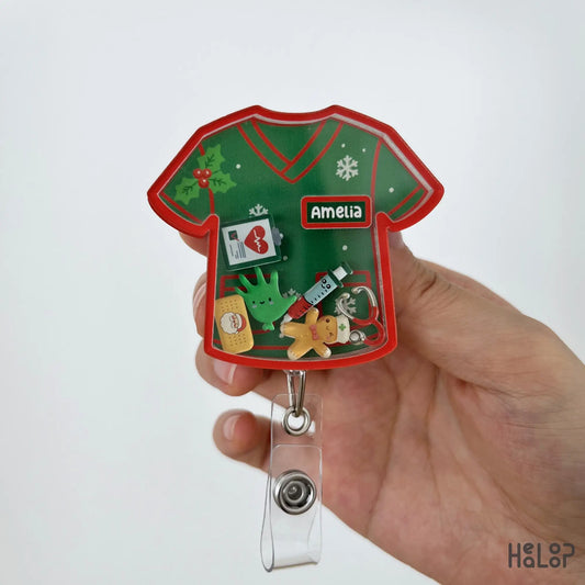 Close-up of a personalized Christmas nurse shaker badge reel with festive healthcare charms and custom name.