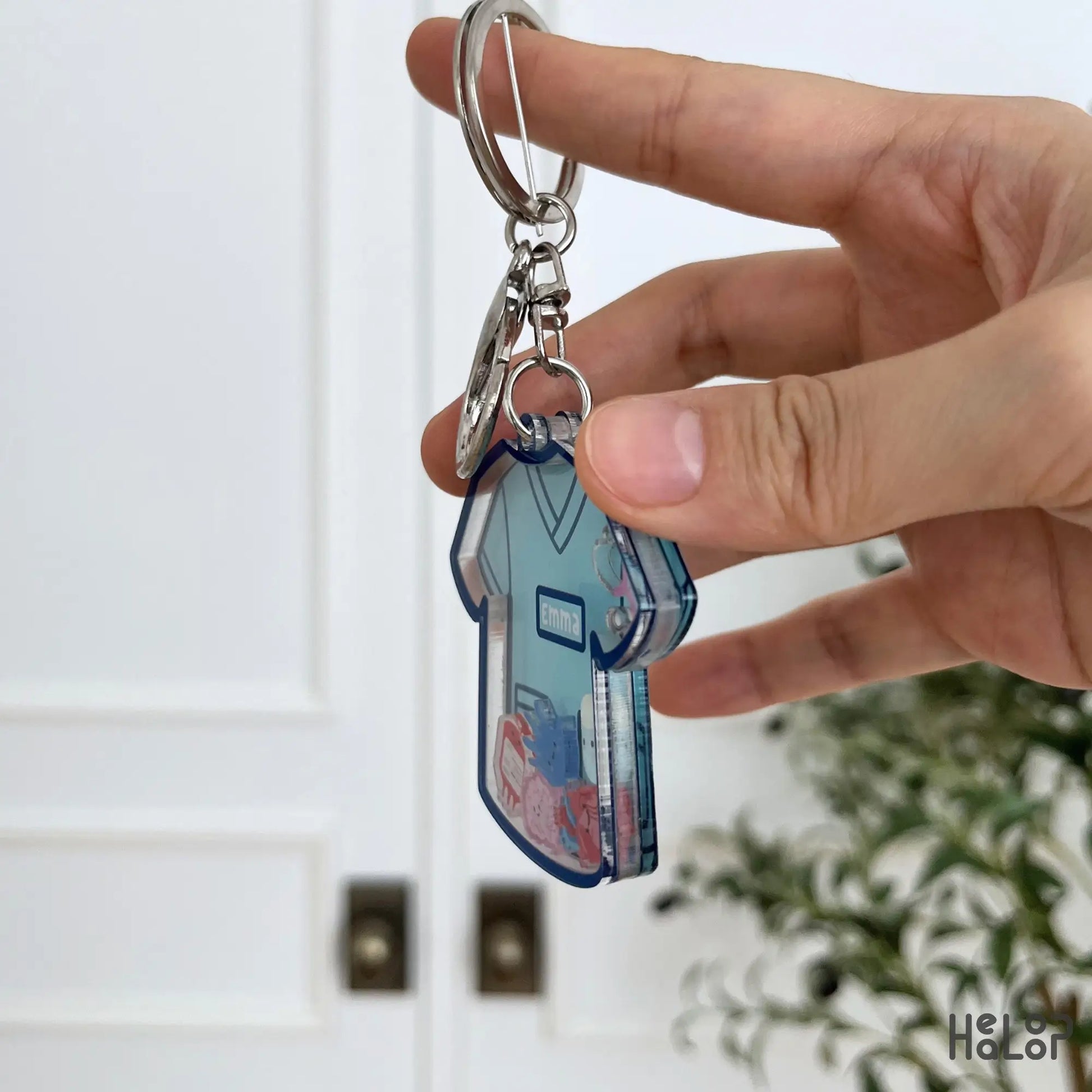 Side view showing the layered acrylic construction of a custom nurse shaker keychain with moving charms.