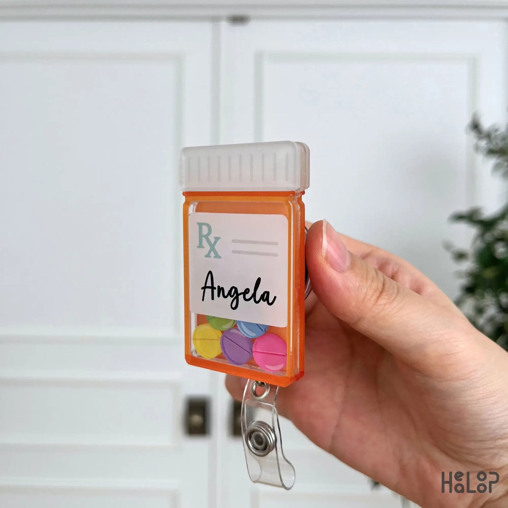 Side profile of a personalized prescription bottle shaker badge reel made for pharmacists and pharmacy technicians.