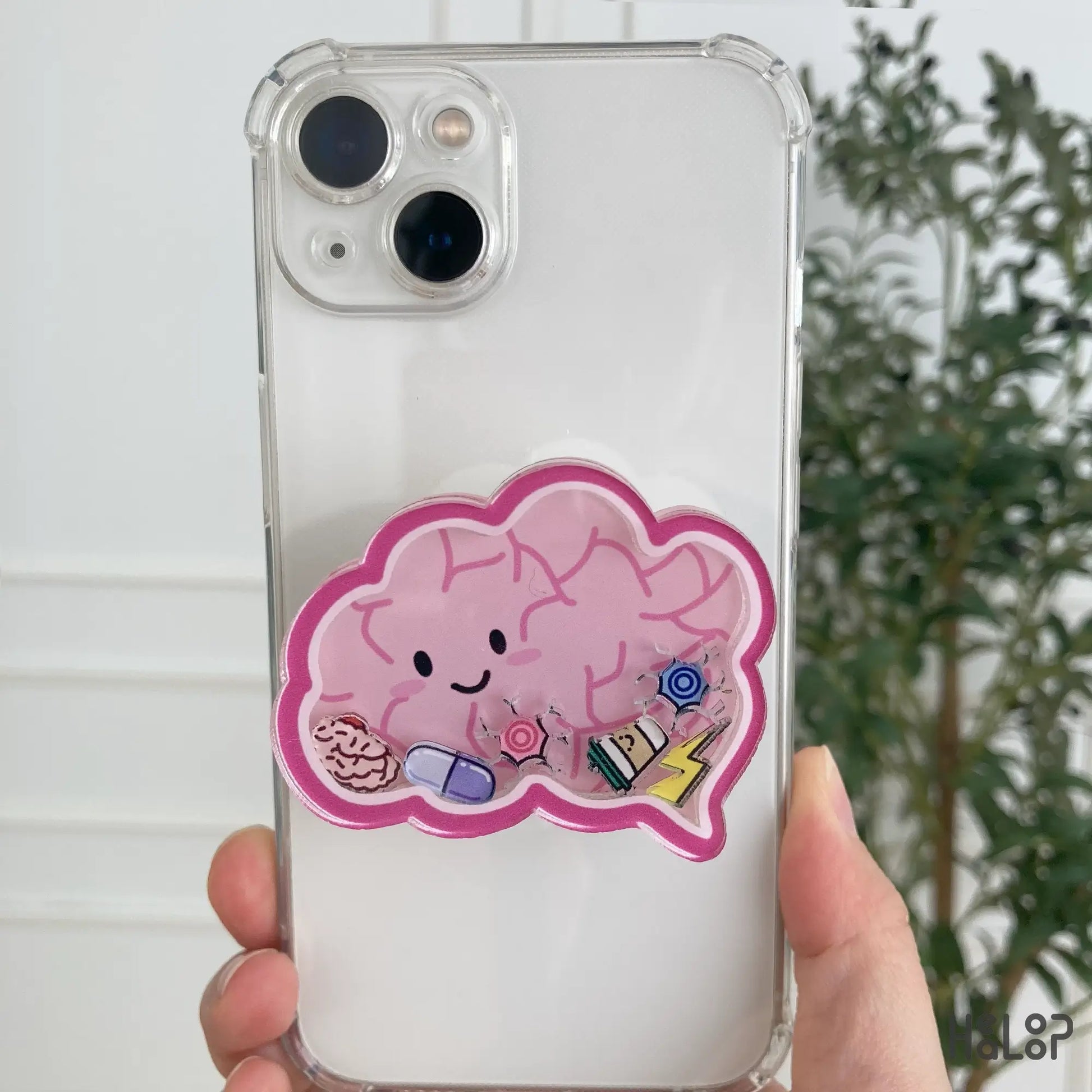 Pink brain shaker phone grip with charms attached to iPhone case