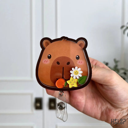 Front view of a cute Capybara shaker badge holder featuring layered acrylic construction and adorable movable charms.