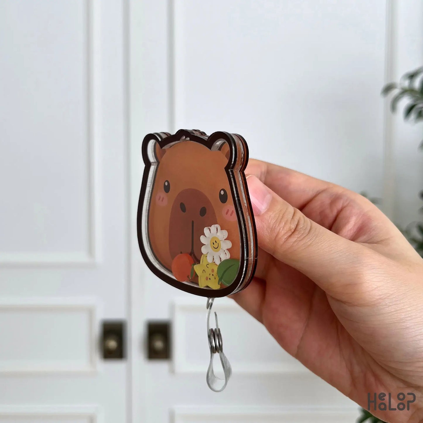 Side view of the Capybara shaker badge reel highlighting the layered acrylic design and durable construction.