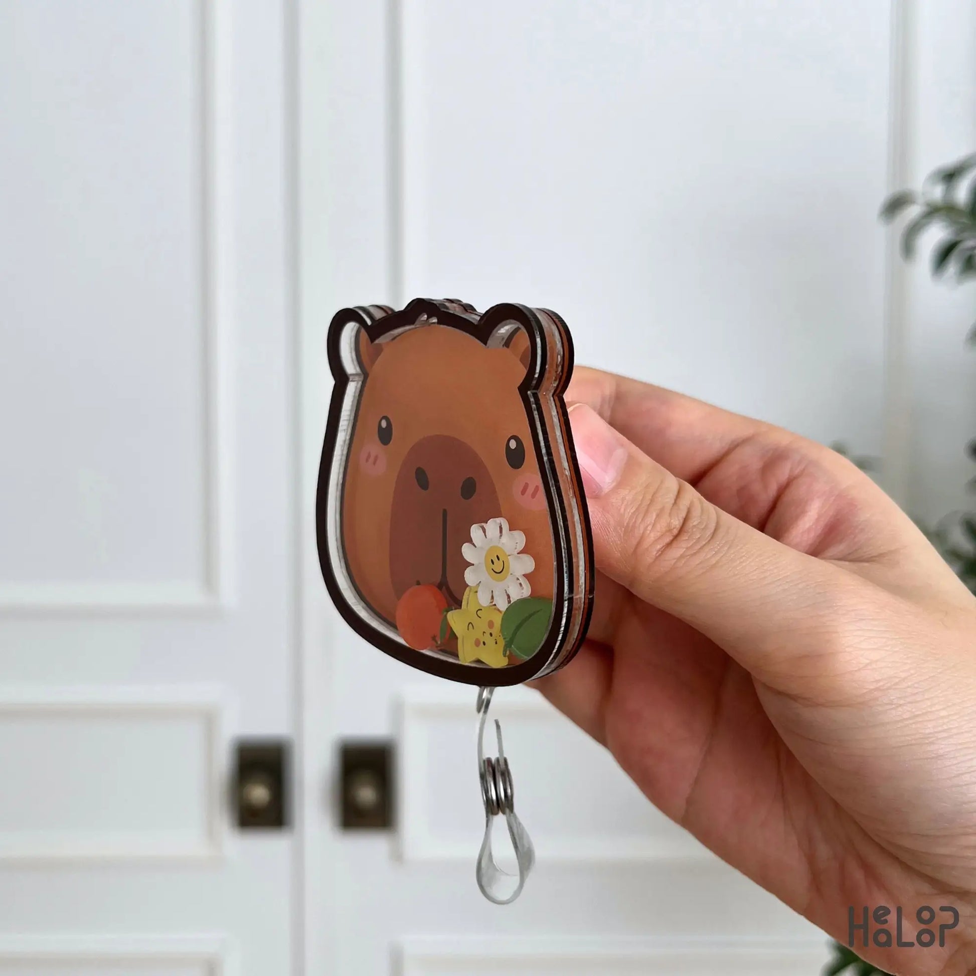 Side view of the Capybara shaker badge reel highlighting the layered acrylic design and durable construction.