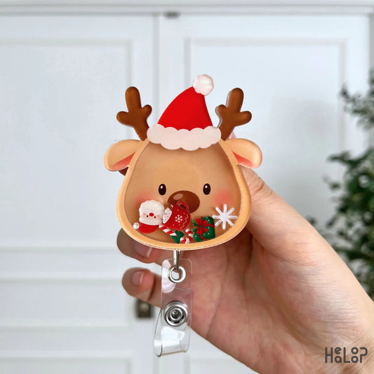 Detailed view of a Christmas Reindeer Shaker Badge Reel with Santa hat, candy cane, Christmas gifts, snowflake, and festive movable charms.