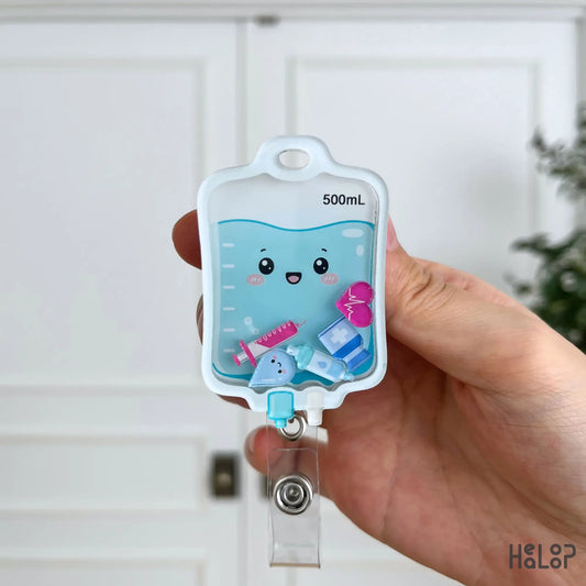 Cute IV Bag Shaker Badge Reel with smiling IV fluid bag and colorful medical shaker charms, perfect for nurses, nursing students and healthcare professionals.