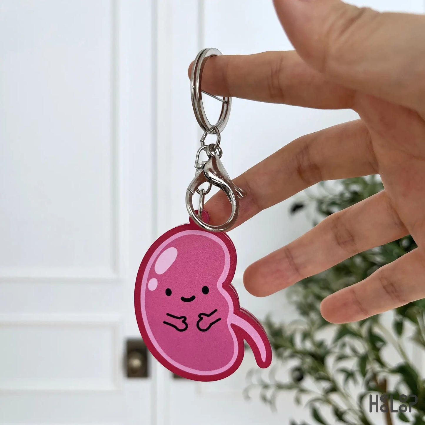 Back view of the cute pink kidney anatomy keychain with a smiling character design.