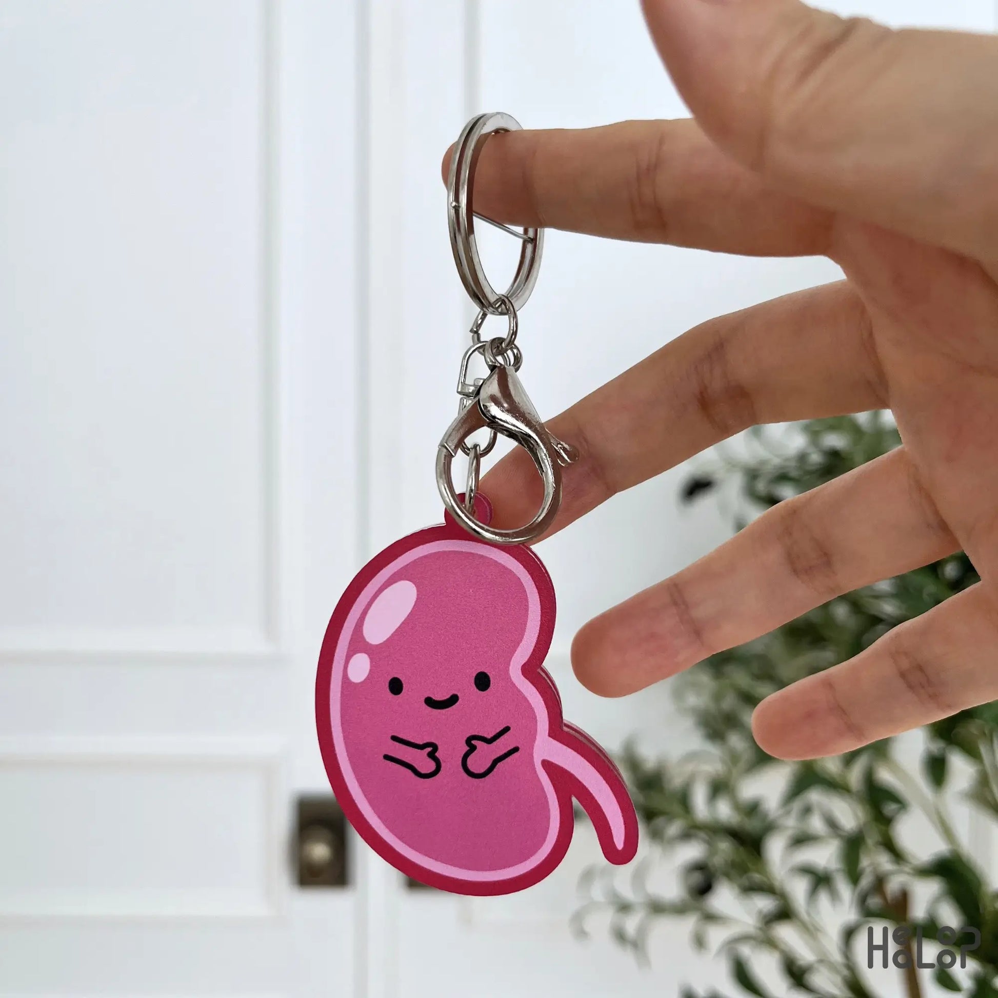 Back view of the cute pink kidney anatomy keychain with a smiling character design.