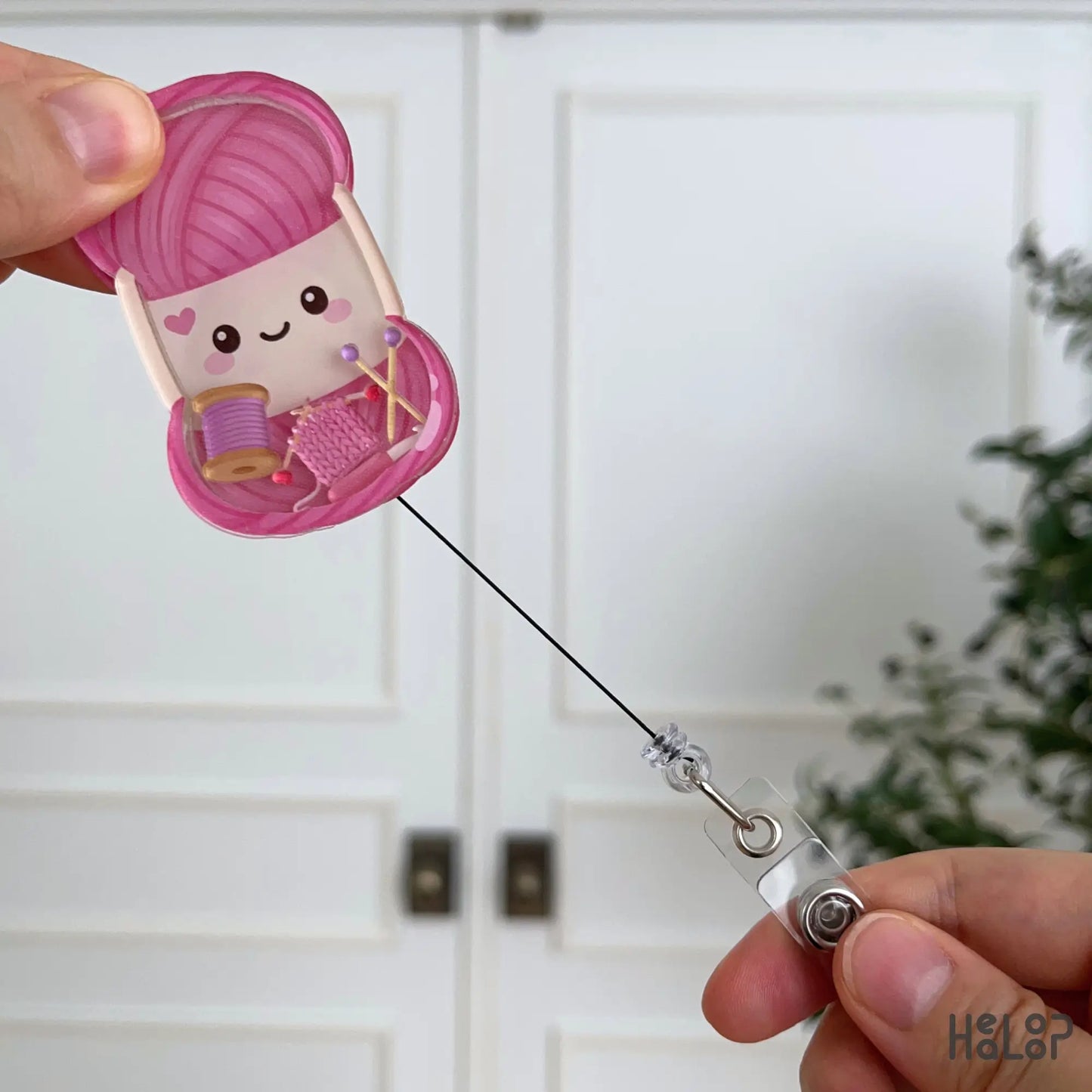 Retractable knitting badge reel with interactive shaker charms, perfect for knitters, crocheters, fiber artists, and yarn lovers.