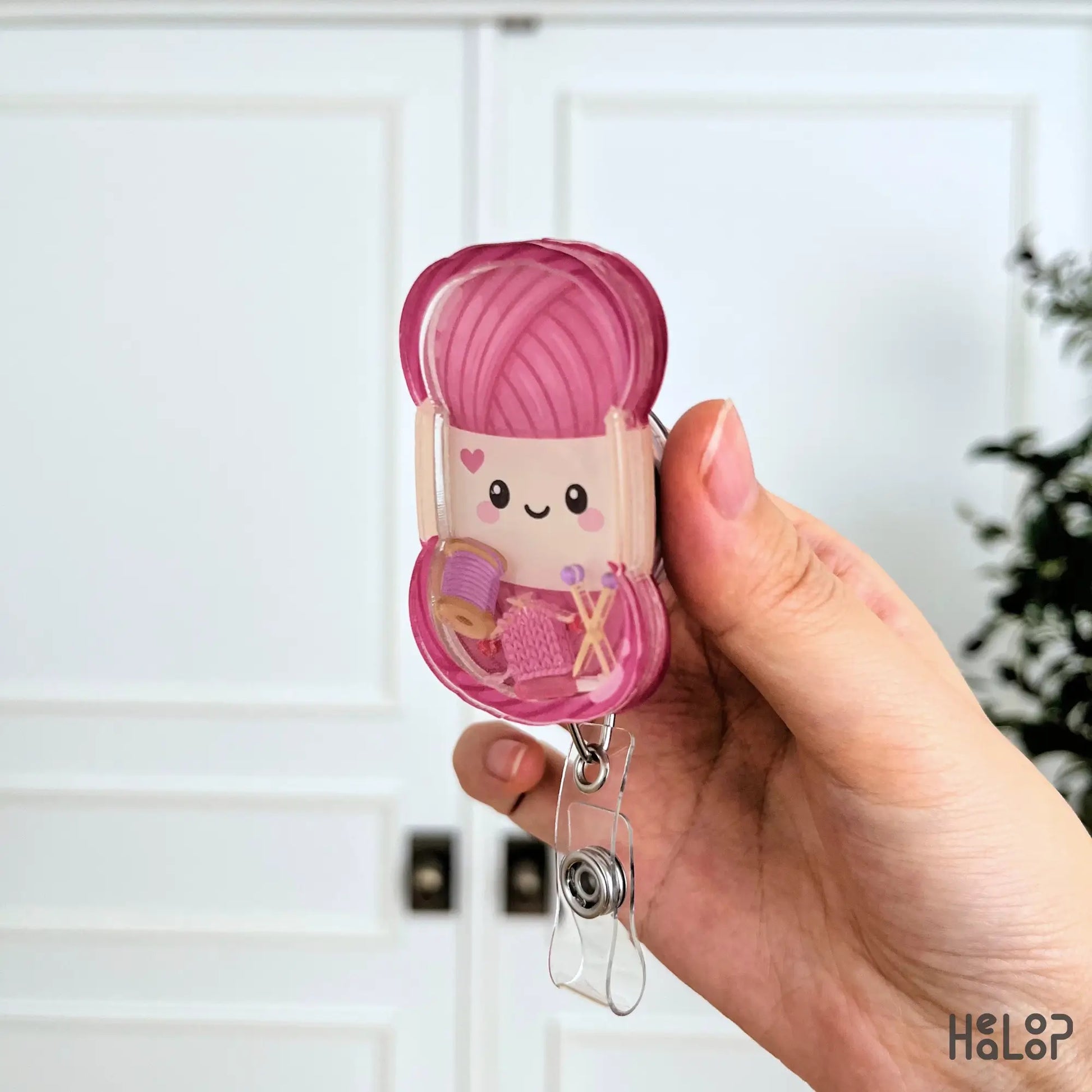 Layered acrylic knitting shaker badge reel shown from the side with cute yarn-themed shaker charms and retractable badge clip.
