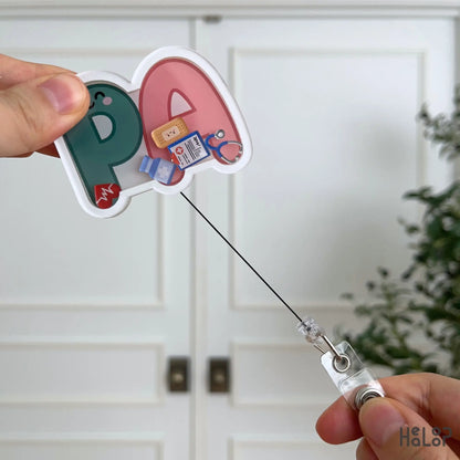 Cute PA Shaker Badge Reel with extended retractable cord demonstrating smooth pull and interactive shaker design.