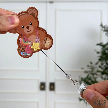 Retractable Teddy Bear Shaker Badge Reel with extended badge cord, featuring interactive acrylic shaker charms for everyday hospital use