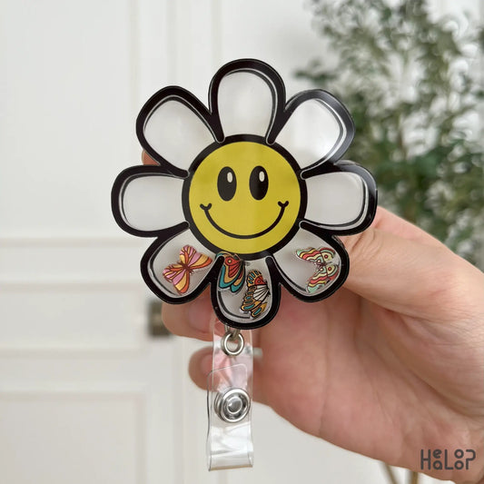 Detailed daisy flower shaker badge reel with butterflies and retractable clip.