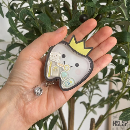 Cute tooth badge reel for dental hygienists and nurses — handheld view showing charm details
