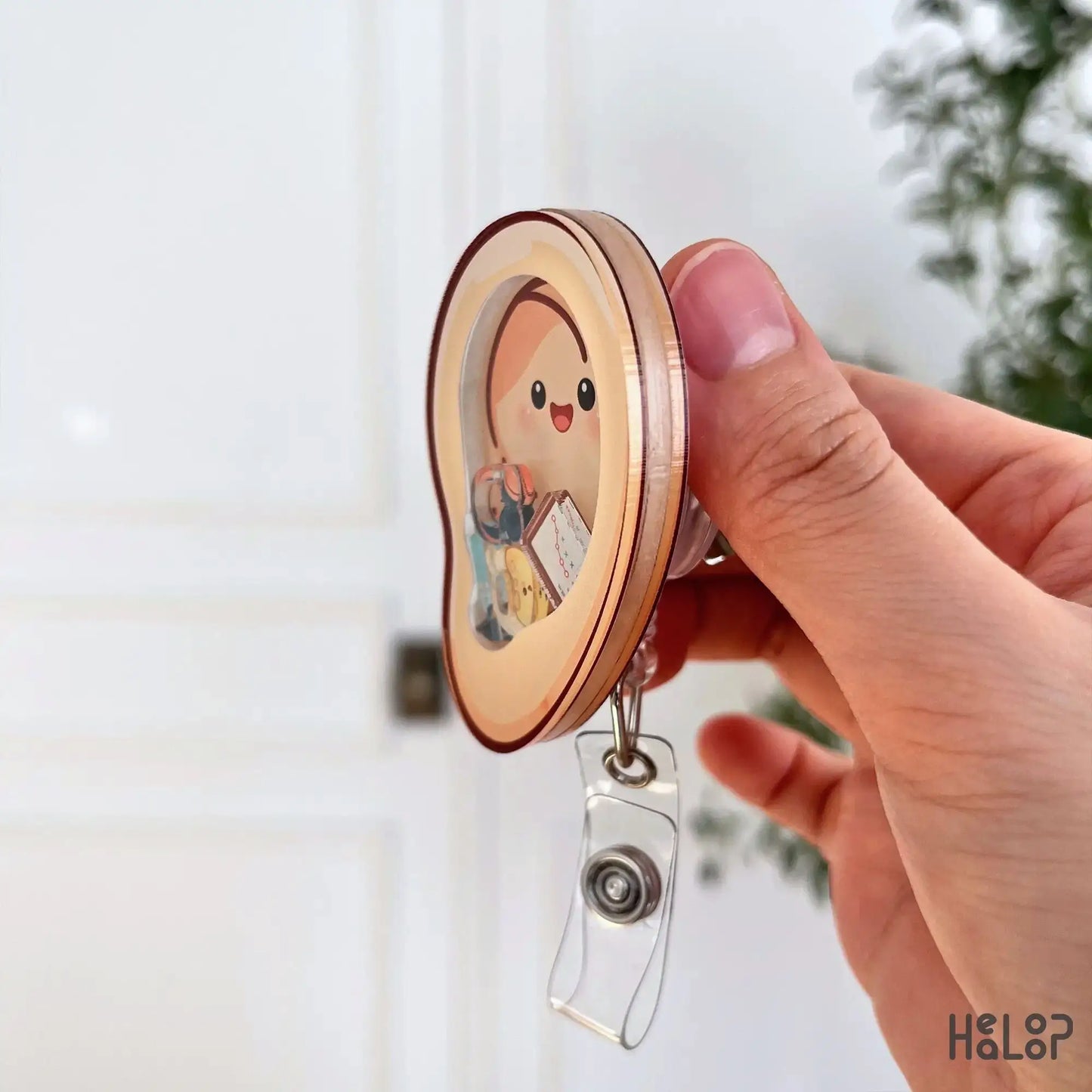 Ear shaped medical badge reel for hearing care professionals